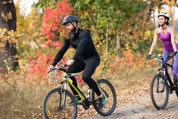 Persone in bicicletta nel parco autunnale — Foto stock