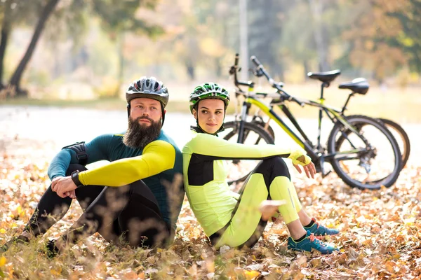 Ciclisti che riposano vicino alle biciclette — Foto stock