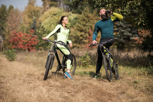 Couple de cyclistes dans le parc d'automne — Photo de stock