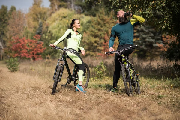 Pareja de ciclistas en el parque de otoño - foto de stock