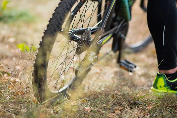 Bicycle with cyclist on dry grass — Stock Photo