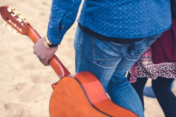 Мужчина с гитарой ходит с женщиной — стоковое фото