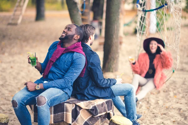 Lächelnde Freunde mit Cocktails beim Picknick — Stockfoto