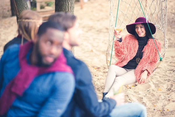 Fashionable woman in net swing with friends — Stock Photo
