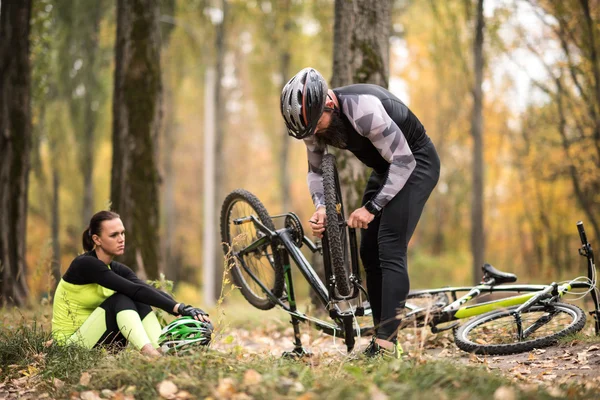 Hombre reparación de bicicletas en el parque - foto de stock