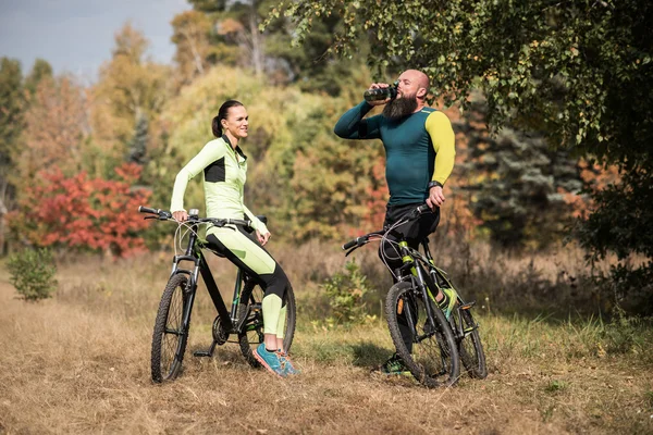 Casal de ciclistas descansando no parque — Fotografia de Stock