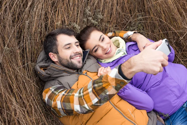 Glückliches Paar macht Selfie im Gras — Stockfoto