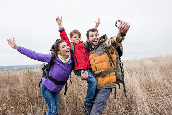 Famiglia felice con zaini che scattano selfie — Foto stock