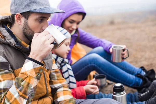 Familia bebiendo té de tazas de metal — Stock Photo