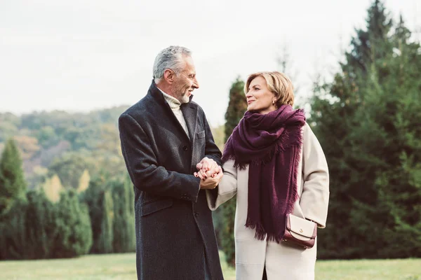 Pareja madura caminando en el parque de otoño - foto de stock