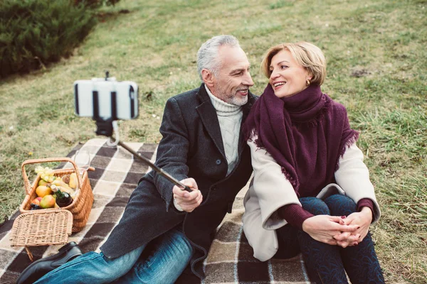 Sonriente pareja madura tomando selfie - foto de stock