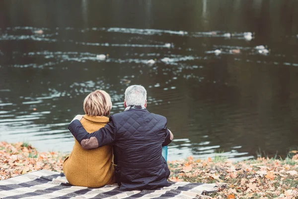 Älteres Paar schaut mit Enten auf See — Stockfoto