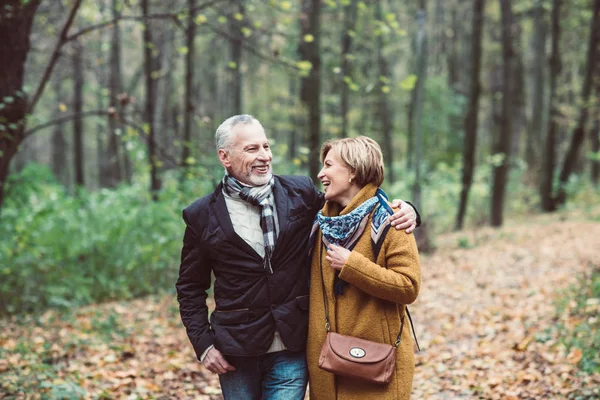 Pareja madura caminando en el parque de otoño - foto de stock