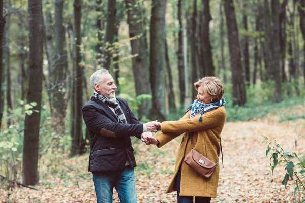 Pareja madura caminando en el parque de otoño - foto de stock