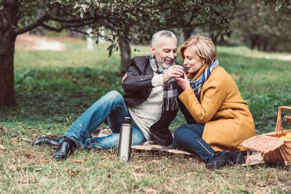 Couple d'âge mûr boire du thé dans le parc — Photo de stock