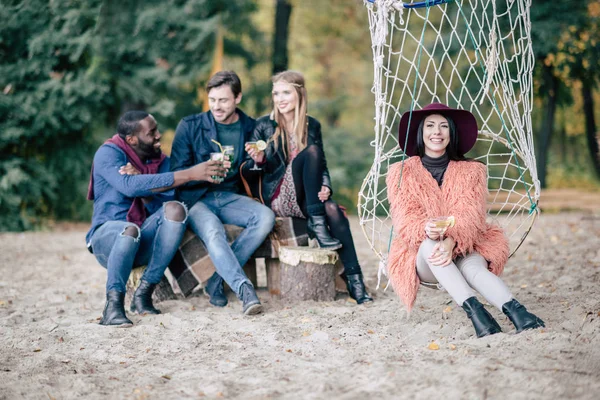 Lächelnde Freunde mit Cocktails beim Picknick — Stockfoto