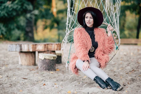 Attractive woman sitting in net swing — Stock Photo