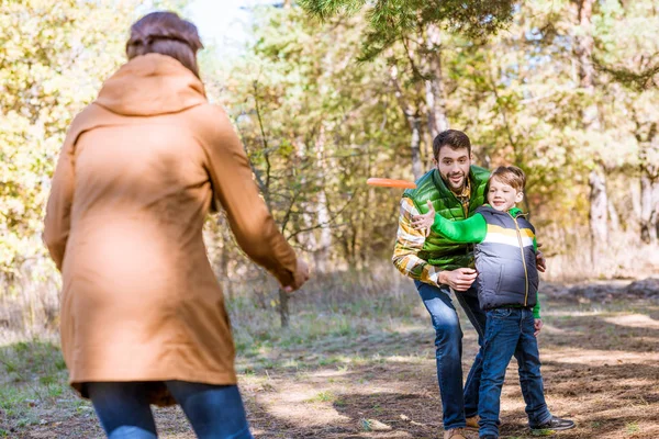 Familia feliz jugando con frisbee - foto de stock