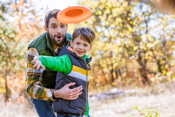 Sonriente padre e hijo jugando con frisbee - foto de stock