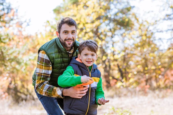 Smiling father and son playing with frisbee — Stock Photo