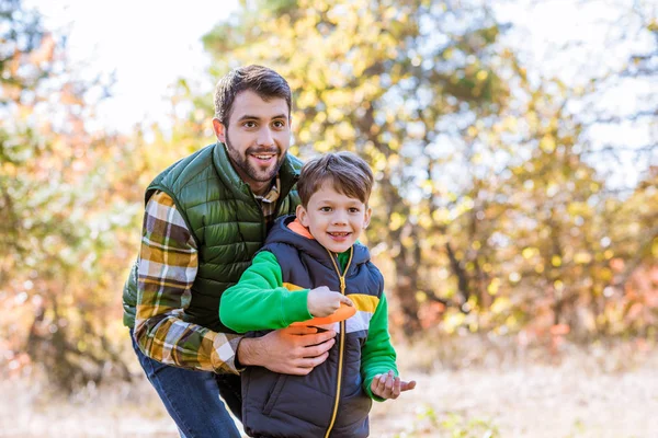 Sorrindo pai e filho brincando com frisbee — Fotografia de Stock