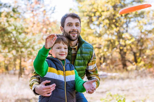 Smiling father and son playing with frisbee — Stock Photo