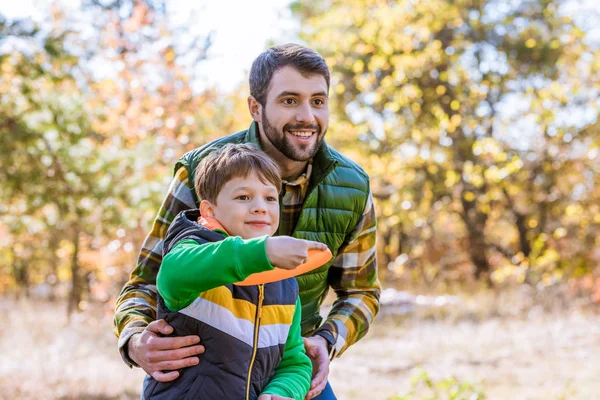 Smiling father and son playing with frisbee — Stock Photo