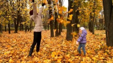 Yaprakları ile oynayan bir çocuk ile anne
