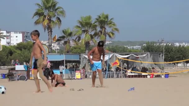 Испанские пляжи Каталонии. Люди загорают на пляже под жарким солнцем . — стоковое видео