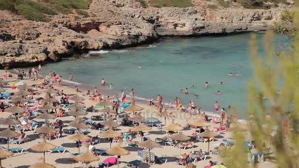 Az emberek fürdőzés és pihenés a tengerparton. Cala Mendia spanyol strandok. Mallorca — Stock videók