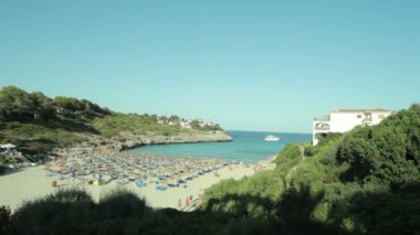 İnsanlar banyo ve sahilde dinlenin. Cala Mendia İspanyol plajları. Mallorca