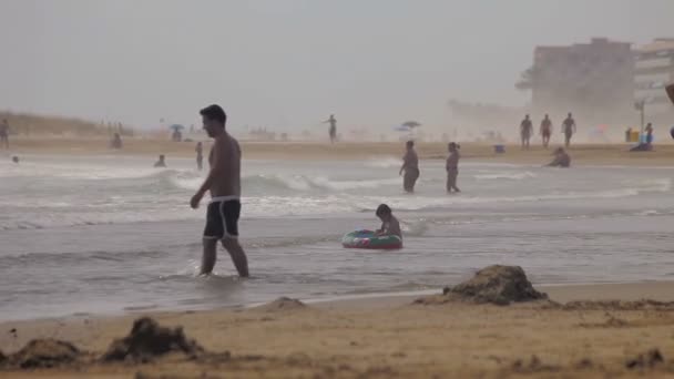 Άνθρωποι κολυμπά και να ξεκουραστούν στην παραλία. Ισπανικές παραλίες στην Καταλονία. — Αρχείο Βίντεο