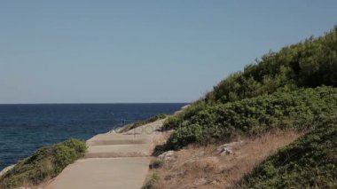 Yollar ve merdiven plajda kayalar yamaçları boyunca. Cala Mendia İspanyol plajları. Mallorca