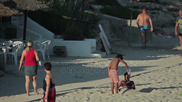La gente si bagna e si riposa sulla spiaggia. Spiagge spagnole a Cala Mendia. Maiorca I bambini giocano nella sabbia . — Video Stock