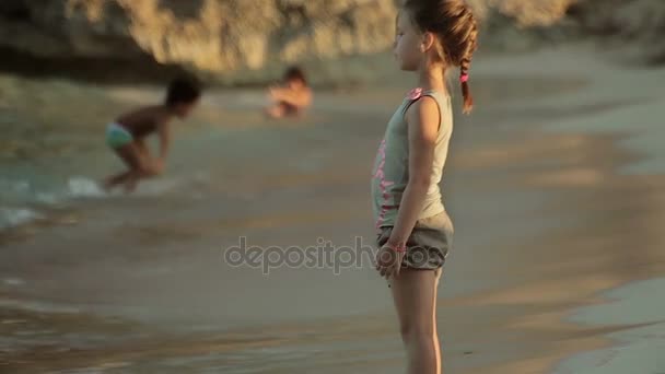 El niño es un ángel. La chica angelical habla y juega con el mar. Playas españolas en Cala Mendia. Mallorca — Vídeos de Stock