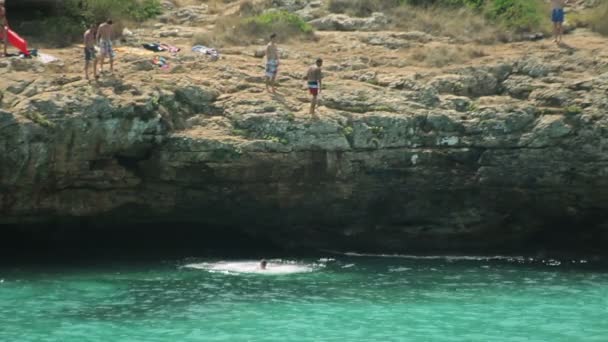 Άνθρωποι κολυμπά και να ξεκουραστούν στην παραλία. Ισπανικές παραλίες της Cala Mendia. Μαγιόρκα — Αρχείο Βίντεο