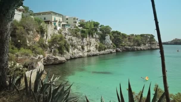 Épületek, a lejtőin a hegy, a tenger-öböl felett. Spanyol parkolási egy vidéki város Porto Cristo Yachtok. Mallorca — Stock videók