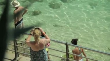 İnsanlar banyo ve şehir sahilde dinlenin. Bikinili kızlar gider taşra kasabasında Porto Cristo sahil boyunca. Mallorca