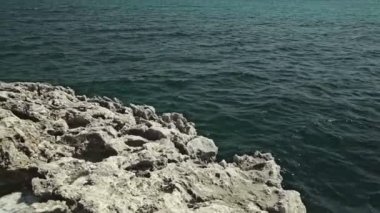 Yaşlı kayalar Körfezi kıyılarında. Rüzgar ve dalgalar taş tarafından bulanık