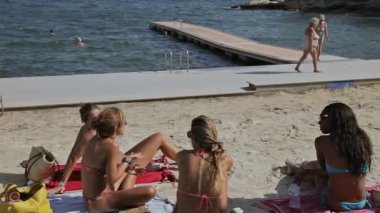 Bir grup genç kızların plajda güneşlenirken bir bikini. Çalışma odasında bir taşra kasabasında Costa Blanes İspanyolca. Mallorca