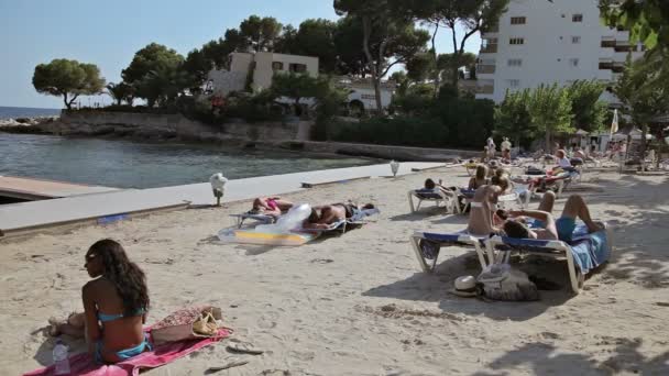 En grupp unga flickor i bikini sola på stranden. Spanska i en landsortsstad Costa den Blanes. Mallorca — Stockvideo