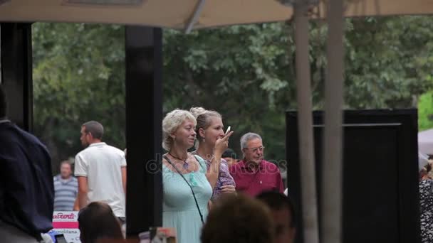 Les touristes fredonnent et se reposent dans les rues de la ville . — Video