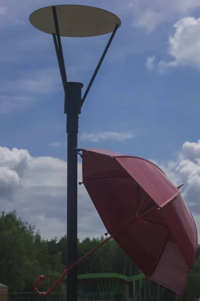 Red umbrella under a lantern — Stock Photo, Image