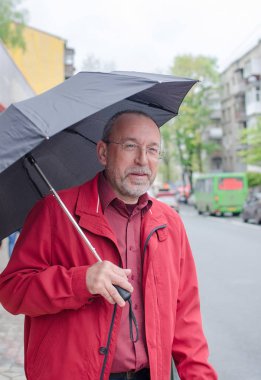 Yaşlı adam yağmur altında