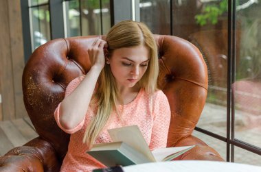 Genç kız kitap ile oturuyor