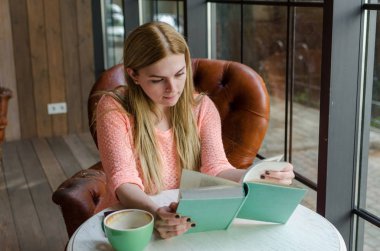 Genç kız kitap ile oturuyor