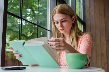 Genç kız kitap ile oturuyor