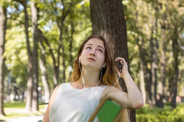 Женщина слушает музыку в парке — стоковое фото