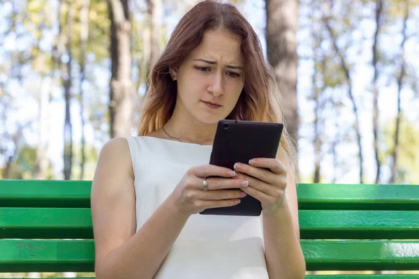 Mujer joven usando su tableta en el parque — Foto de Stock