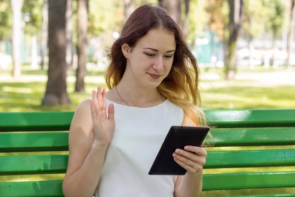 Mujer joven usando su tableta en el parque — Foto de Stock